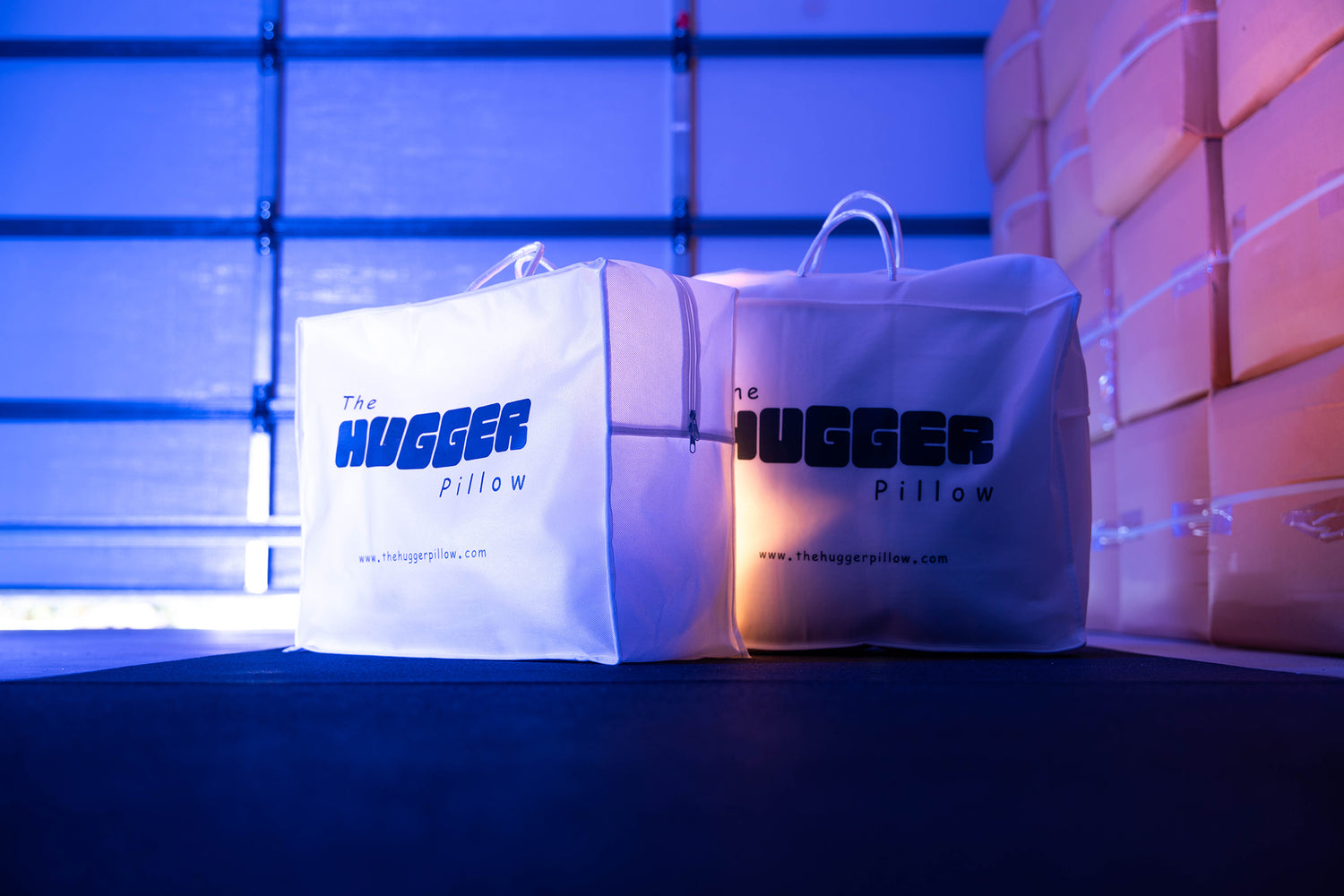 This is the hero cover image on the Shipping and Returns page, showing two Hugger Pillow packages in a warehouse or garage